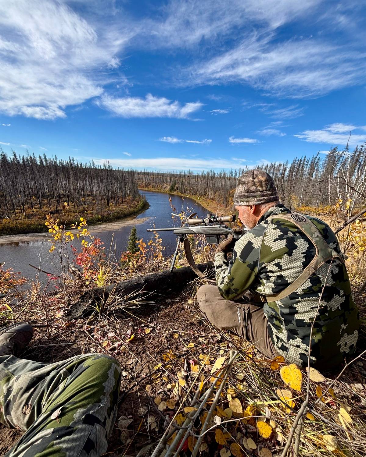 Hunter glassing a river valley from a ridge in Alberta